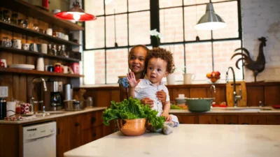 A cozy kitchen with woven placemats, linen curtains, and a patterned runner on a wooden table.