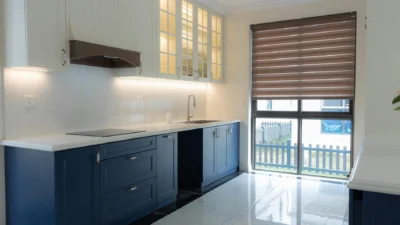 A refreshed kitchen cabinet door with new paint and modern hardware, showing a budget-friendly update.