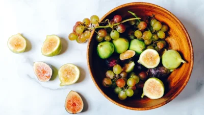 Stylish kitchen counter with a wooden fruit bowl, marble tray, and glass canisters for pantry storage.