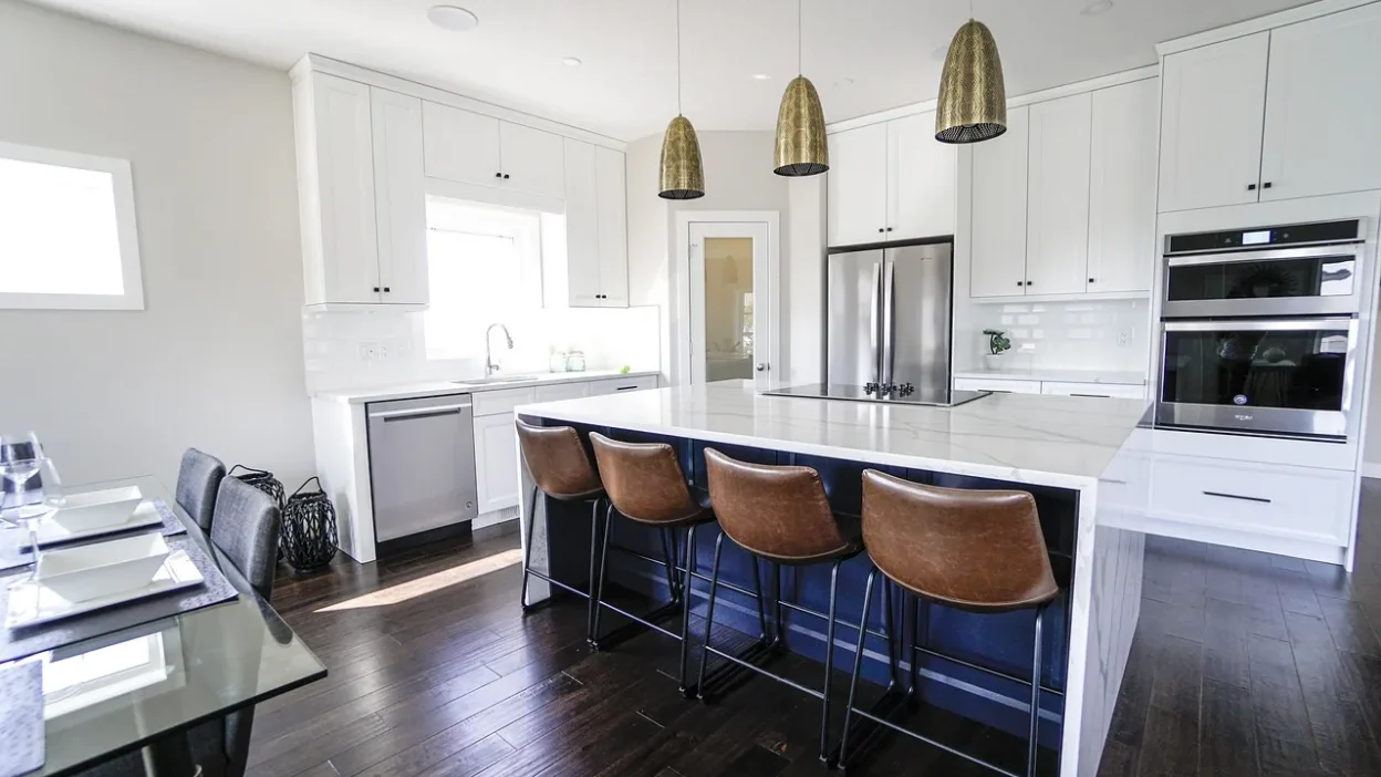 Modern kitchen with marble countertops, decorative bowls, and pendant lighting for stylish surface updates
