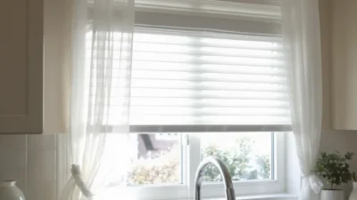 Modern kitchen window with Roman shades, plants, and clean trim for optimal light and privacy.